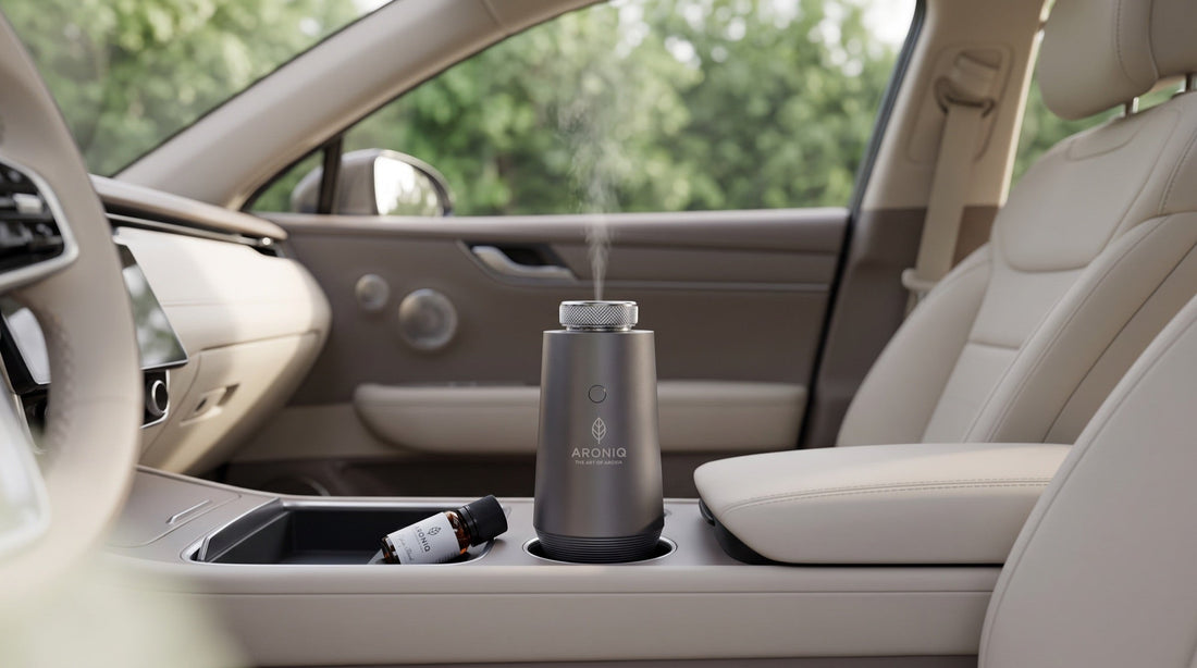 ARONIQ autodiffuser in de bekerhouder met een dunne nevel en een flesje olie uit de zon